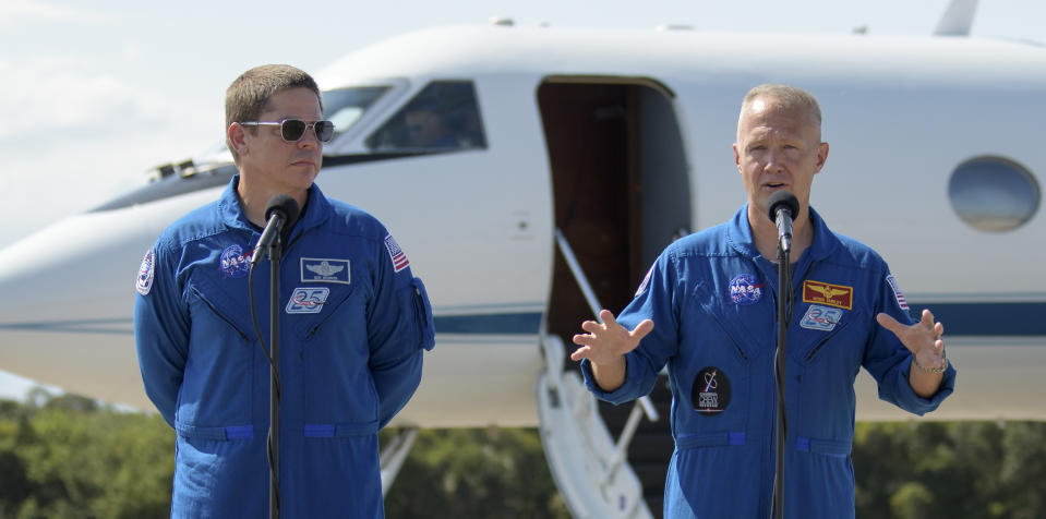 In this photo provided by NASA, astronauts Robert Behnken, left, and Douglas Hurley speak during a news conference after they arrived at the Kennedy Space Center in Cape Canaveral, Fla., Wednesday, May 20, 2020. The two astronauts will fly on the SpaceX Demo-2 mission to the International Space Station scheduled for launch on May 27. (Bill Ingalls/NASA via AP)