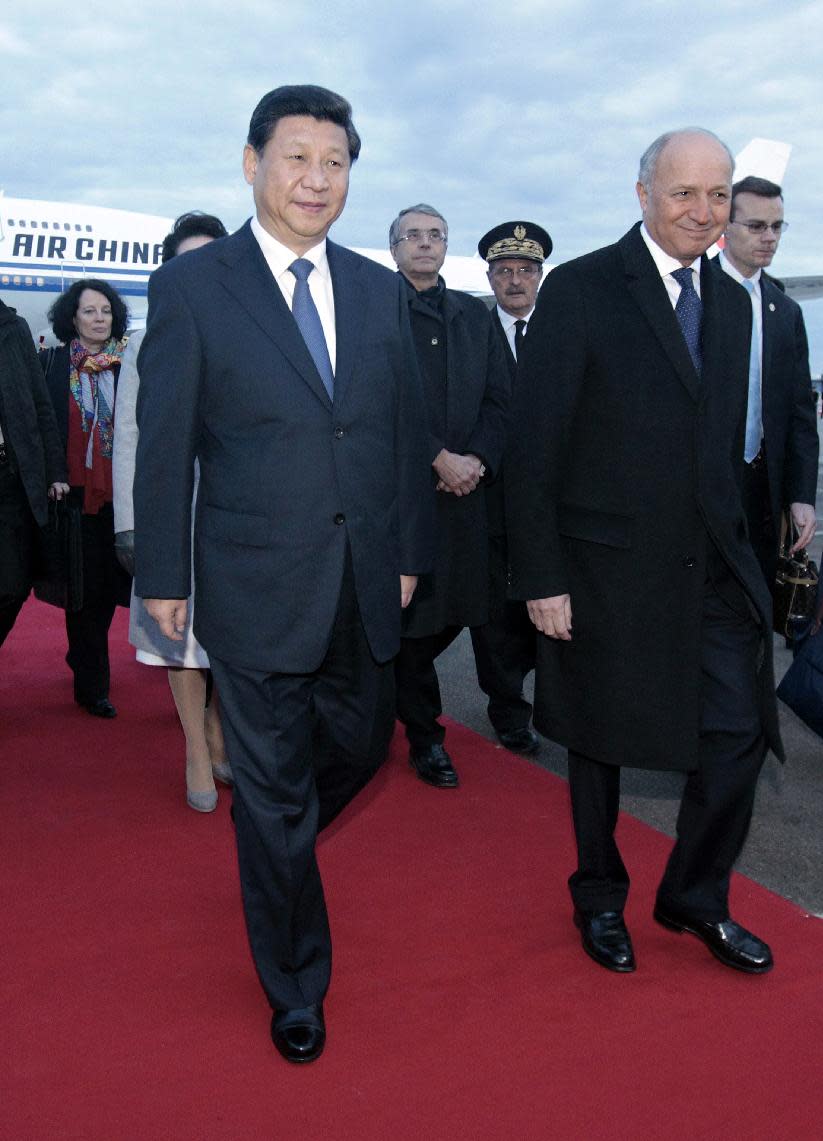 Chinese President Xi Jinping' left. is welcomed by French Foreign Minister Laurent Fabius at Lyon airport, central France, Tuesday, March 25, 2014. Xi will later have a dinner at the Lyon town-hall and has arrived in France for a three-day state visit. (AP Photo/Str)