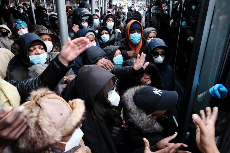 People form a large crowd as they attempt to receive testing kits from city workers in Brooklyn on Christmas Eve.