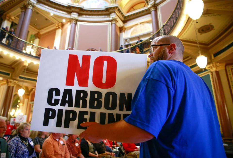 Brian McClain holds up a sign March 29, 2022, as hundreds of concerned landowners from across Iowa gathered in the rotunda at the Iowa Capitol in Des Moines to voice their concerns about the use of eminent domain to acquire land for proposed carbon pipelines.