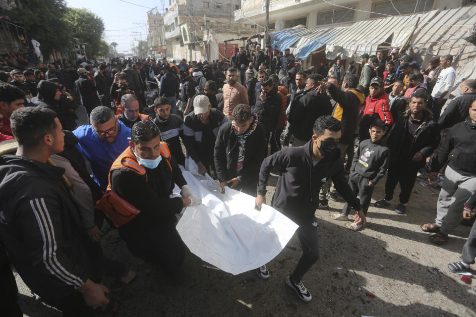 Palestinians evacuate the body of a person killed in an Israeli airstrike on a car in Rafah, Gaza Strip, Friday, Dec. 22, 2023 (AP Photo/Hatem Ali)