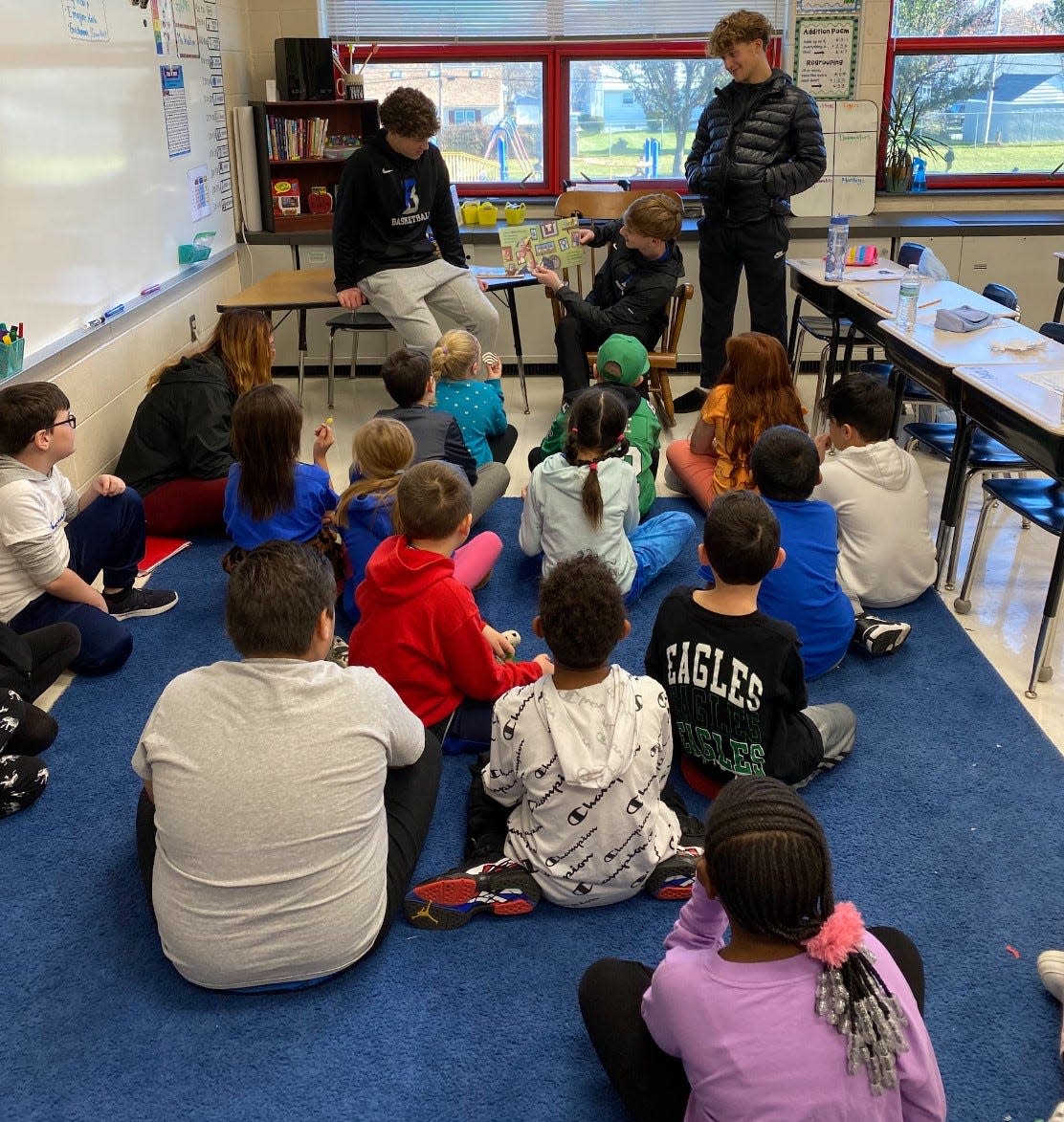 Bensalem senior basketball player Antonio Morris reads to students at Cornwells Elementary School.