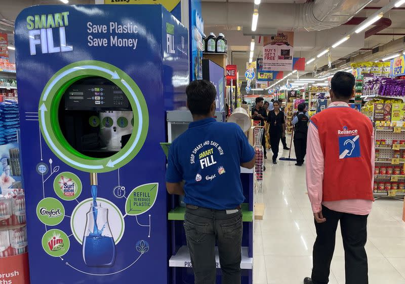 FILE PHOTO: A Unilever employee removes a bottle from a 'Smart Fill' refilling machine inside a supermarket in Mumbai