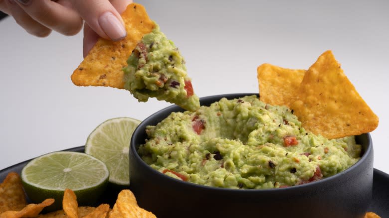 Nachos dipped in guacamole