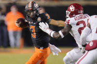 Oklahoma State quarterback Spencer Sanders (3) carries past Oklahoma linebacker Brian Asamoah (24) during the second half of an NCAA college football game Saturday, Nov. 27, 2021, in Stillwater, Okla. (AP Photo/Sue Ogrocki)