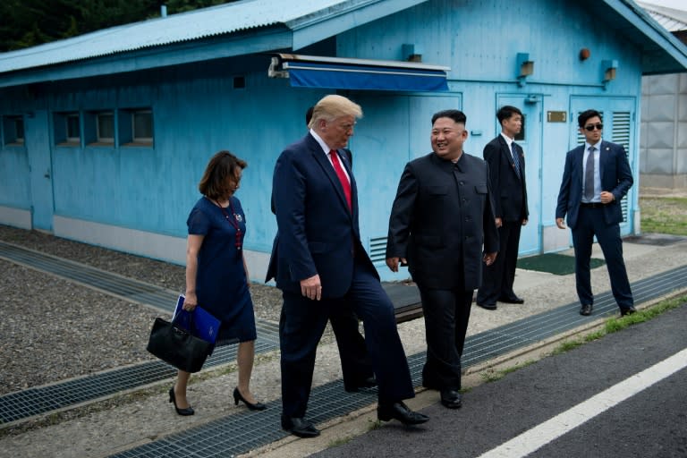 North Korea's leader Kim Jong Un and US President Donald Trump walk together south of the Military Demarcation Line that divides North and South Korea, after Trump briefly stepped over to the northern side in a historic first