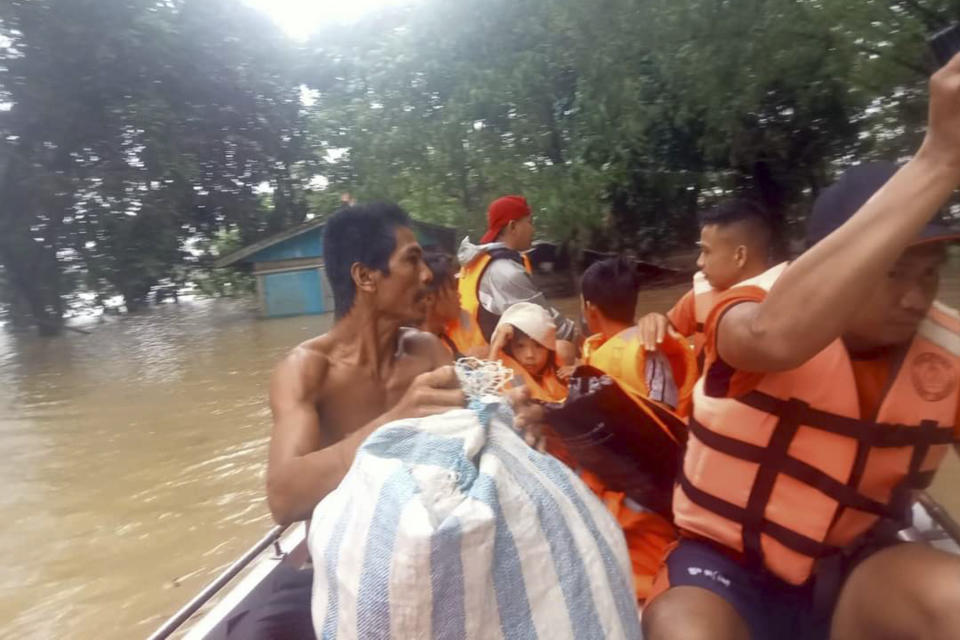 In this photo provided by the Philippine Coast Guard, rescuers use boats to evacuate residents from flooded areas due to Tropical Storm Nalgae at Sigma, Capiz province, Philippines on Friday Oct. 28, 2022. Floodwaters rapidly rose in many low-lying villages, forcing some villagers to climb to their roofs, where they were rescued by army troops, police and volunteers, officials said. (Philippine Coast Guard via AP)