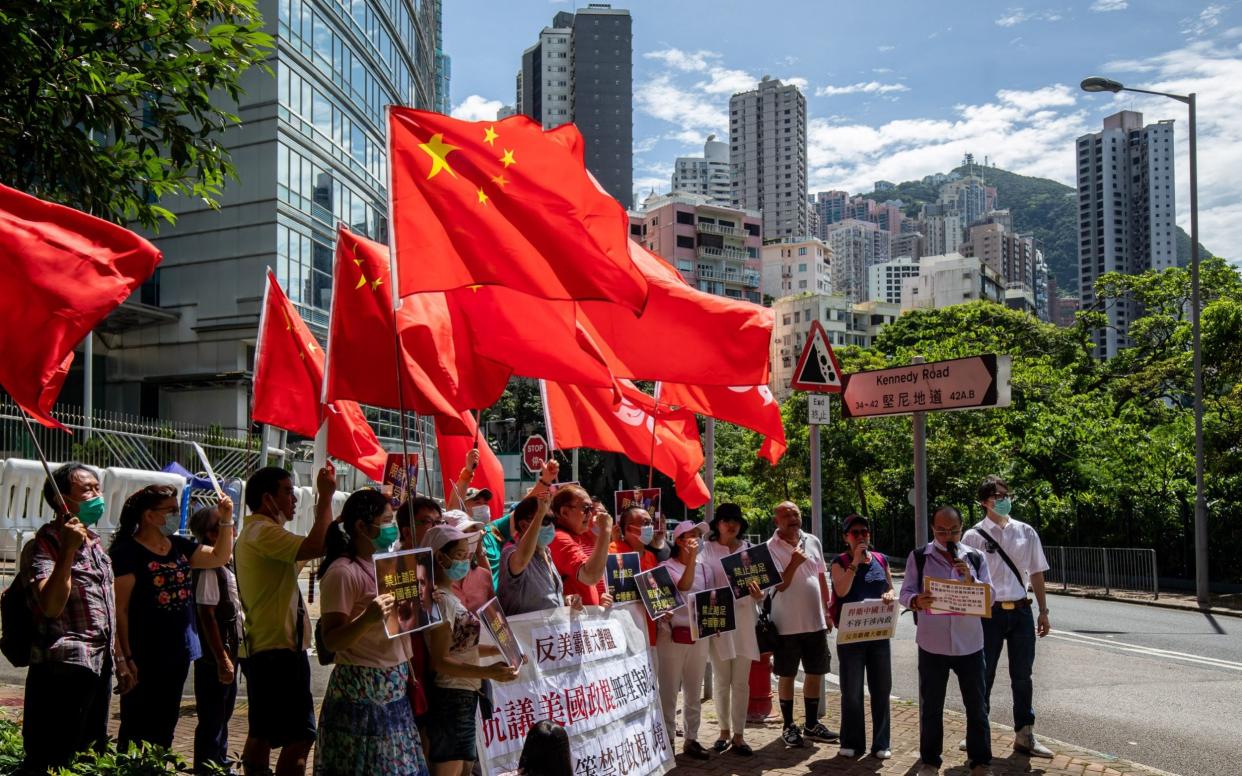 Protesters wave flags outside the Commissioner's Office of China's Foreign Ministry in Hong Kong - Bloomberg