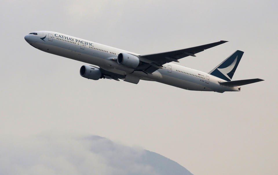 In this March 26, 2019 photo, a Cathay Pacific Airways passenger aircraft takes off at the Hong Kong International Airport. Cathay Pacific Airways is acquiring Hong Kong-based budget airline HK Express. Cathay said Wednesday, March 27, 2019, it will pay 4.93 billion Hong Kong dollars ($628 million) for HK Express. It said the acquisition will retain its identity as a separate brand and be operated as a low-cost carrier. (AP Photo/Kin Cheung)