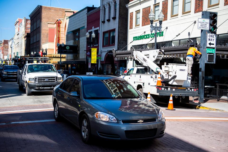 Cars drive down Gay St. past where a noise-detection camera is being installed at the corner of Gay St. and Clinch Ave. in downtown Knoxville on Monday, Feb. 14, 2022.