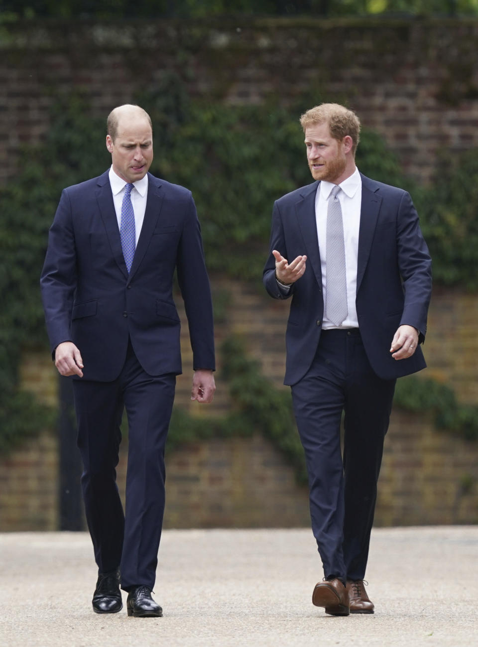 El príncipe Guillermo de Inglaterra, a la izquierda, y su hermano, el príncipe Enrique, llegan para develar una estatua que encargaron de su madre, la princesa Diana, en el que habría sido su 60 cumpleaños, el jueves 1 de julio de 2021 en el Jardín Hundido del Palacio de Kensington, en Londres. (Yui Mok/Pool Photo via AP)