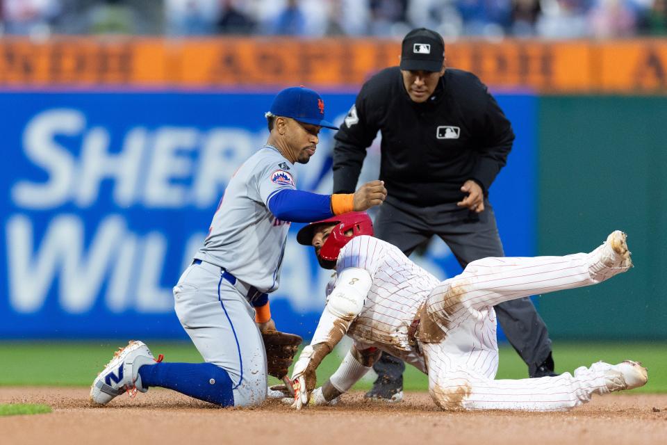 Philadelphia Phillies outfielder Nick Castellanos (8) is tagged out at second base by New York Mets shortstop Francisco Lindor (12) while attempting to stretch a single during the fourth inning on May 15, 2025, at Citizens Bank Park.
