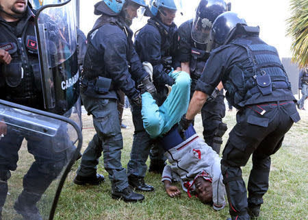 Italian police evacuate a migrant from the Saint Ludovic border crossing on the Mediterranean Sea between Vintimille, Italy and Menton, France, June 16, 2015. REUTERS/Eric Gaillard