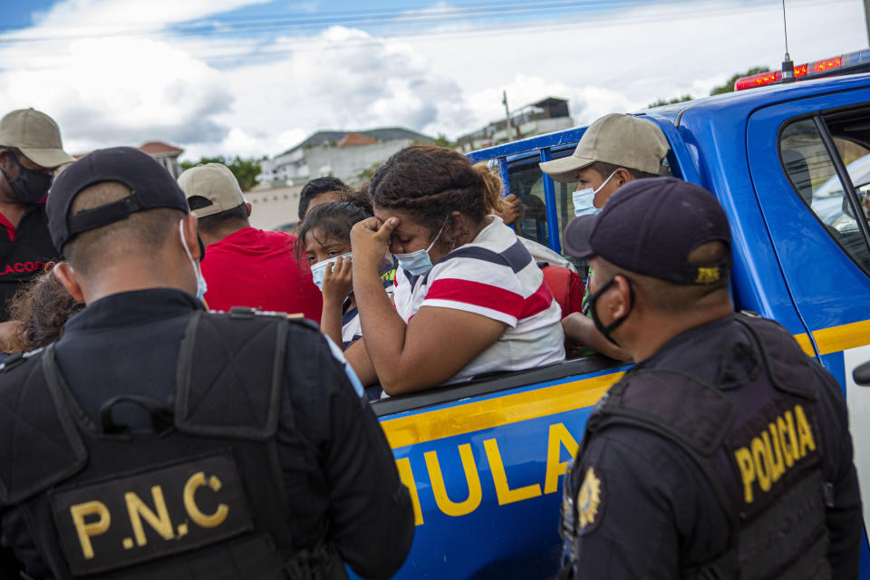 A Honduran migrant woman trying to reach the U.S. cries after she was detained in the Guatemalan department of Chiquimula, Tuesday, Jan. 19, 2021. A once large caravan of Honduran migrants that pushed its way into Guatemala last week had dissipated by Tuesday in the face of Guatemalan security forces. (AP Photo/Oliver de Ros)