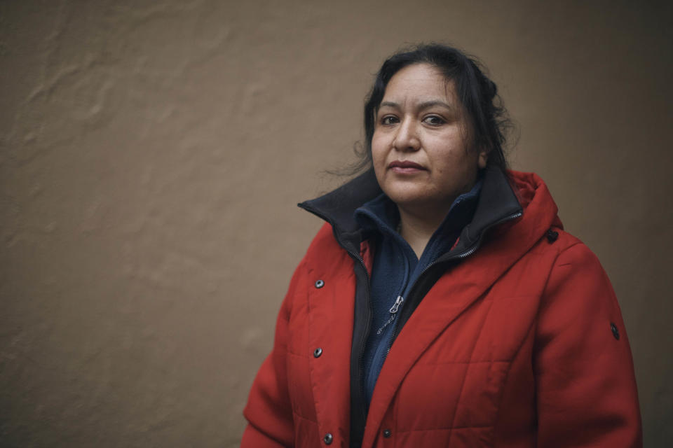 Migrant Karina Obando, from Ecuador, poses for a portrait in front of the Row Hotel that serves as migrant shelter on Tuesday, Dec. 12, 2023, in New York. Obando who lives with Efren and her 3-year-old daughter Maily Caiza, in the Row Hotel that serves as migrant shelter, has received an eviction notice. (AP Photo/Andres Kudacki)