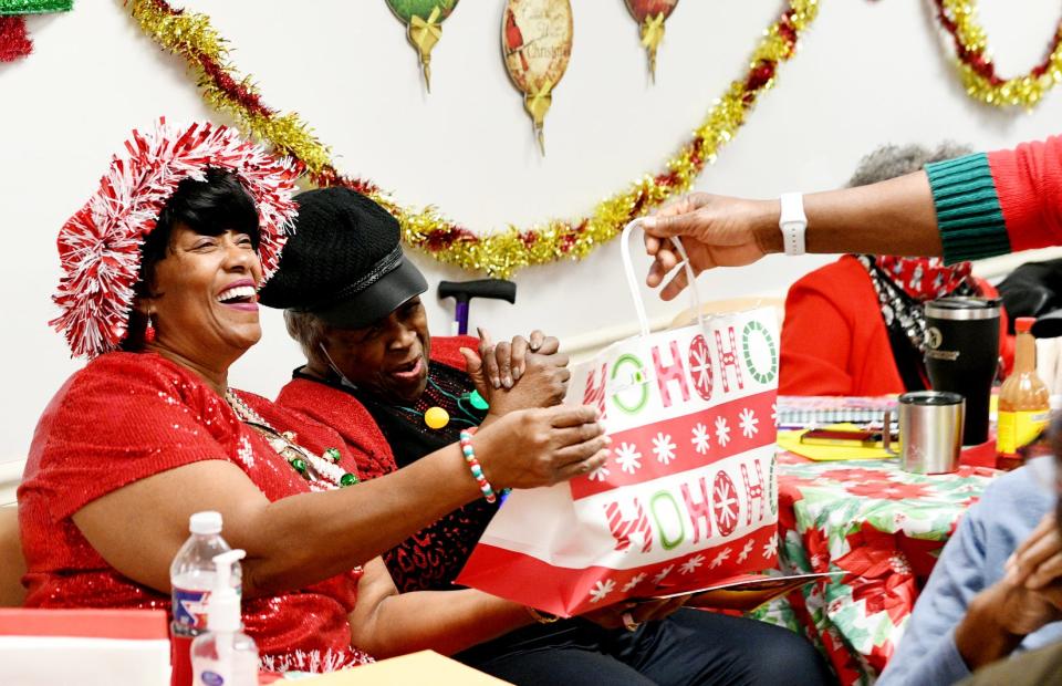 Carol Smith gets a present during the Martin Luther King, Jr. Neighborhood Association Christmas luncheon, Thursday morning, December 21, 2023.