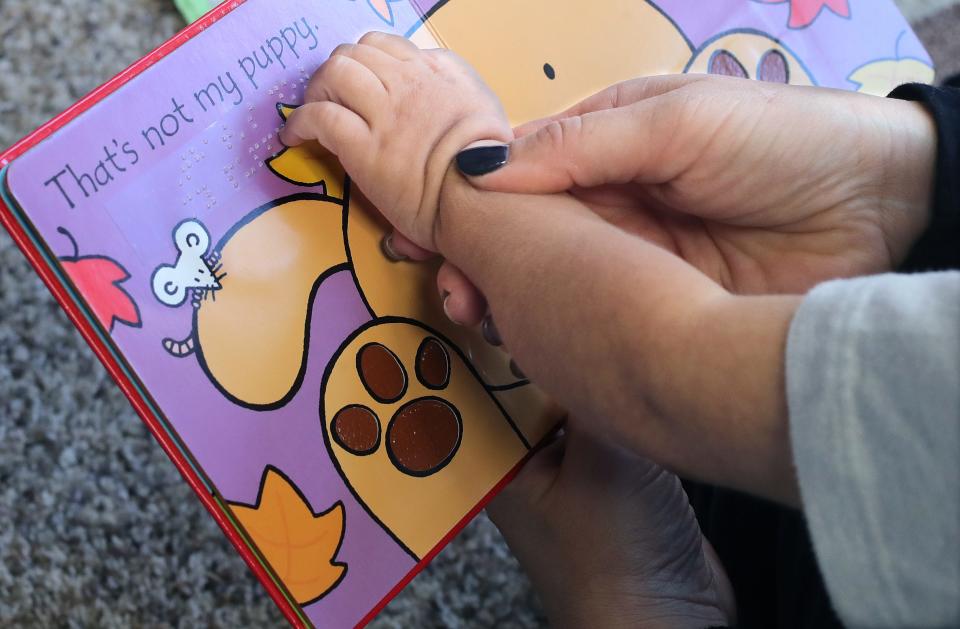 Carlla Detwiler reads a book in Braille with her son David.