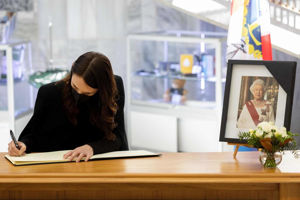 New Zealand’s Prime Minister Jacinda Ardern writes in a condolence book (AFP via Getty Images)