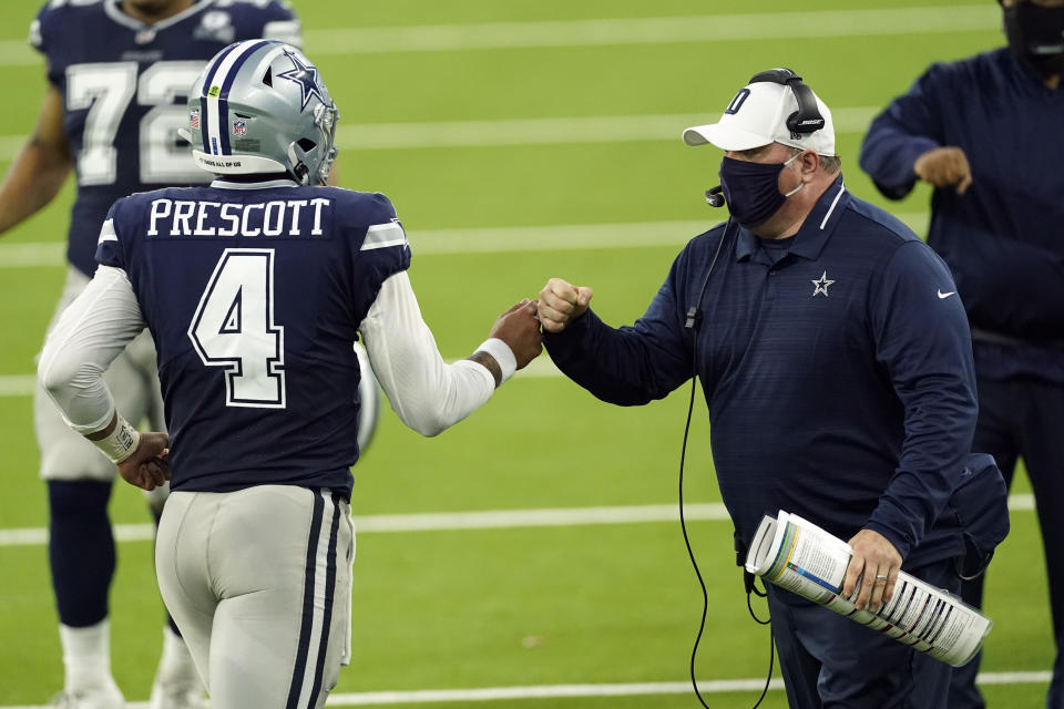 Dallas Cowboys head coach Mike McCarthy bumps fists with quarterback Dak Prescott (4) during the first half of an NFL football game against the Los Angeles Rams Sunday, Sept. 13, 2020, in Inglewood, Calif. (AP Photo/Ashley Landis )