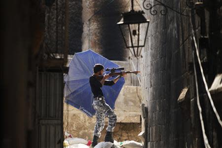 A Free Syrian Army fighter aims his weapon as he takes a defensive position in the old city of Aleppo, September 3, 2013. REUTERS/Muzaffar Salman