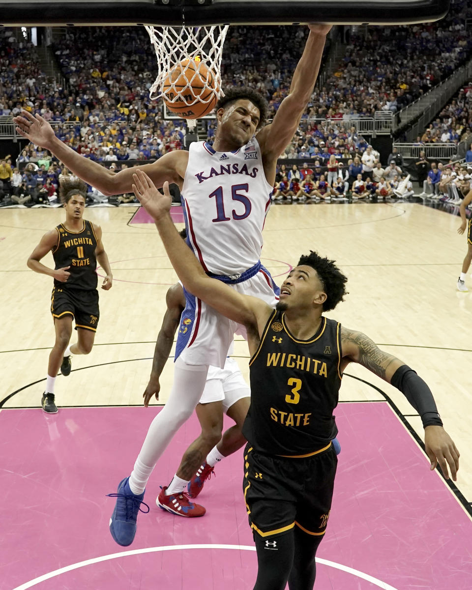 Kansas guard Kevin McCullar Jr. (15) gets past Wichita State forward Ronnie DeGray III (3) to dunk the ball during the first half of an NCAA college basketball game Saturday, Dec. 30, 2023, in Kansas City, Mo. (AP Photo/Charlie Riedel)