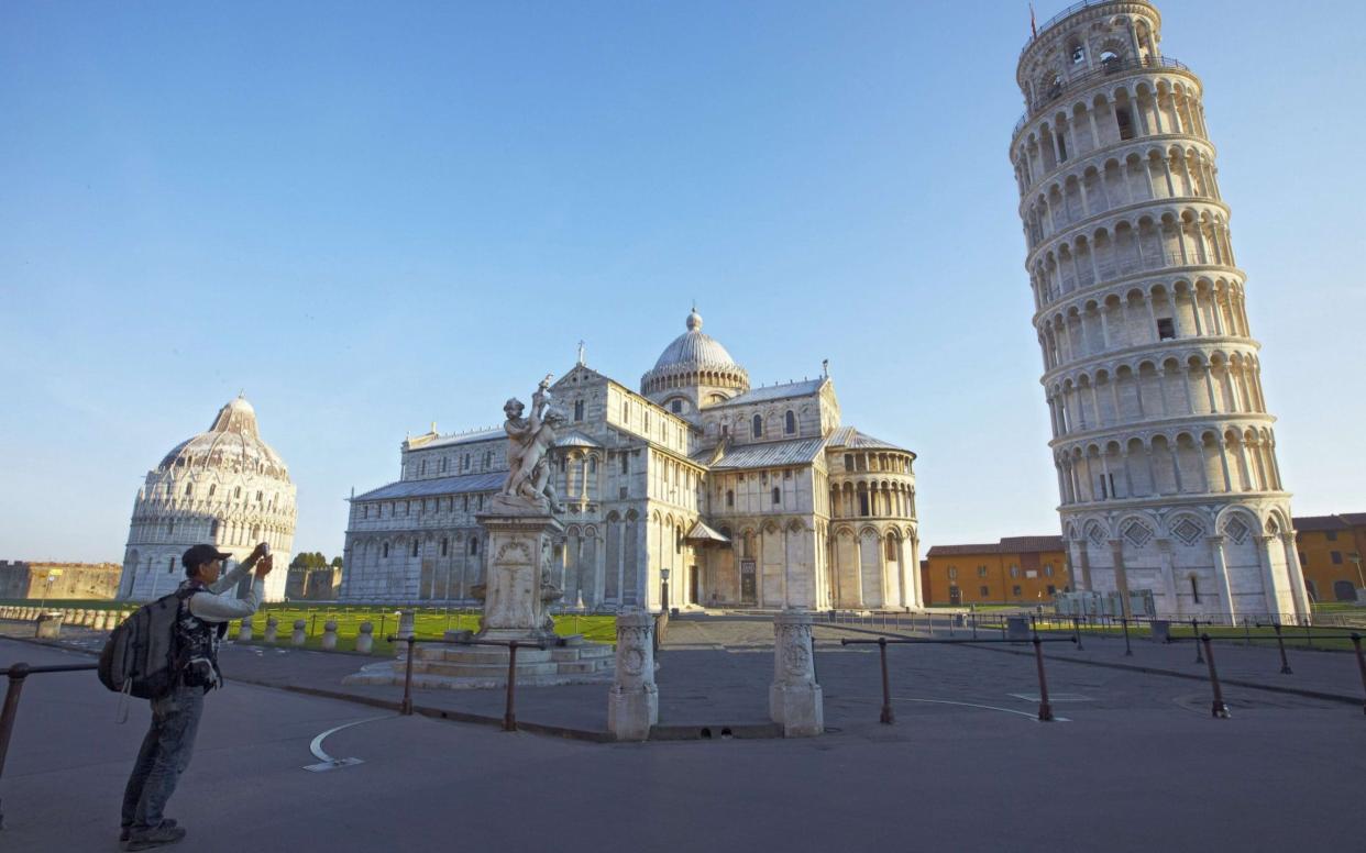 Pisa's famous Leaning Tower, along with the cathedral and baptistry, as the sun comes up - AFP