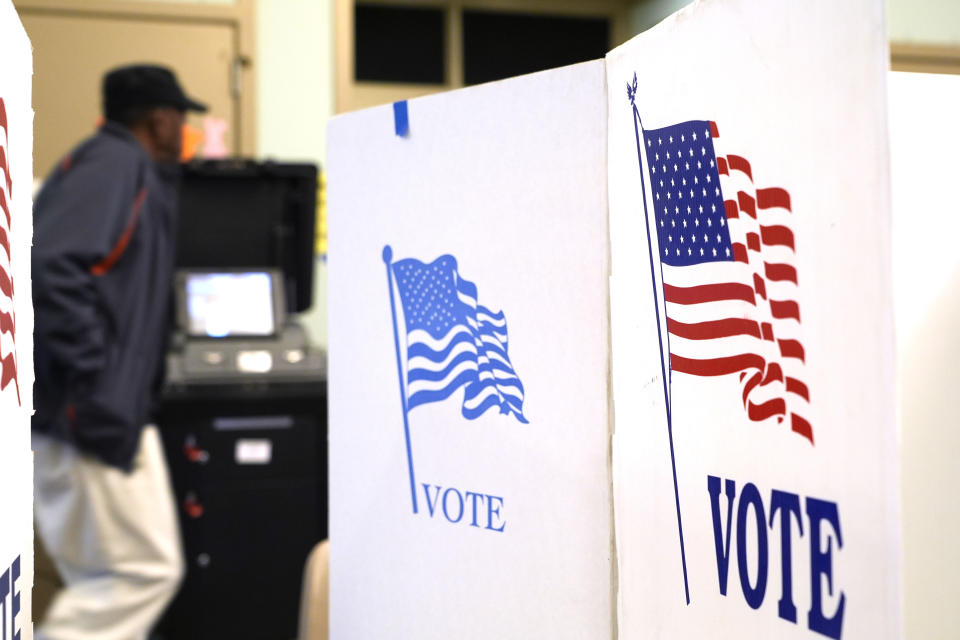 A Hinds County poll worker walks past ballot kiosks at this north Jackson, Miss., election precinct during Mississippi's party primaries, Tuesday, March 12, 2024. (AP Photo/Rogelio V. Solis)