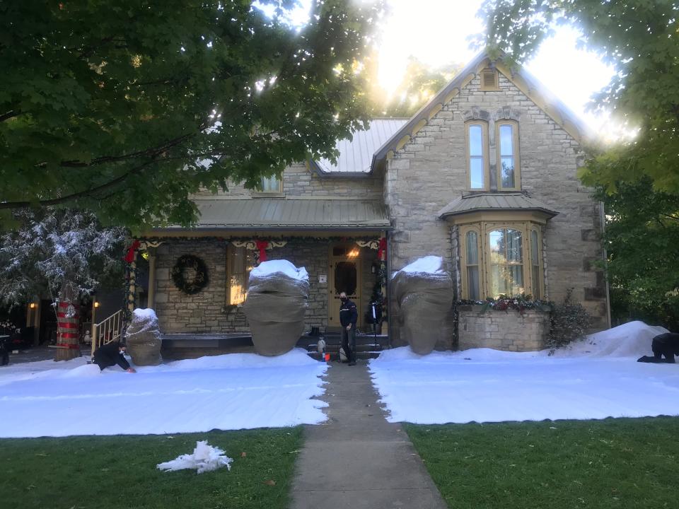House with fake snowed laid in front of it to create a Christmas look during the summertime.