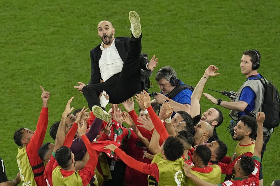 Morocco coach Walid Regragui is thrown in the air by players celebrating the team's historic World Cup win over Spain