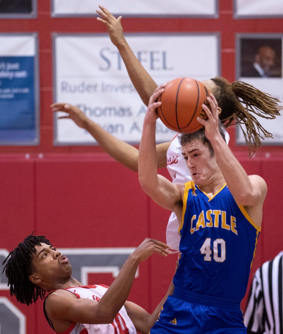 Castle's Weston Aigner (40) pulls down a rebound ahead of Bosse's Royal Elliott (10) and Tizaun Tomlinson (1) during their game at Bosse High School Thursday night, Feb. 2, 2023.