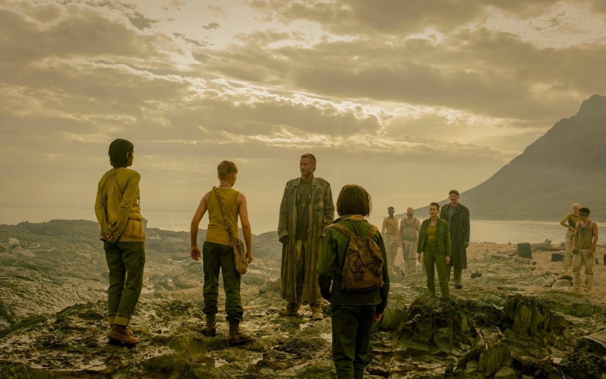 Marcus (Travis Fimmel) stands among a crowd of prisoners on a rocky planet in the HBO / Sky Atlantic / NowTV show Raised By Wolves - HBO