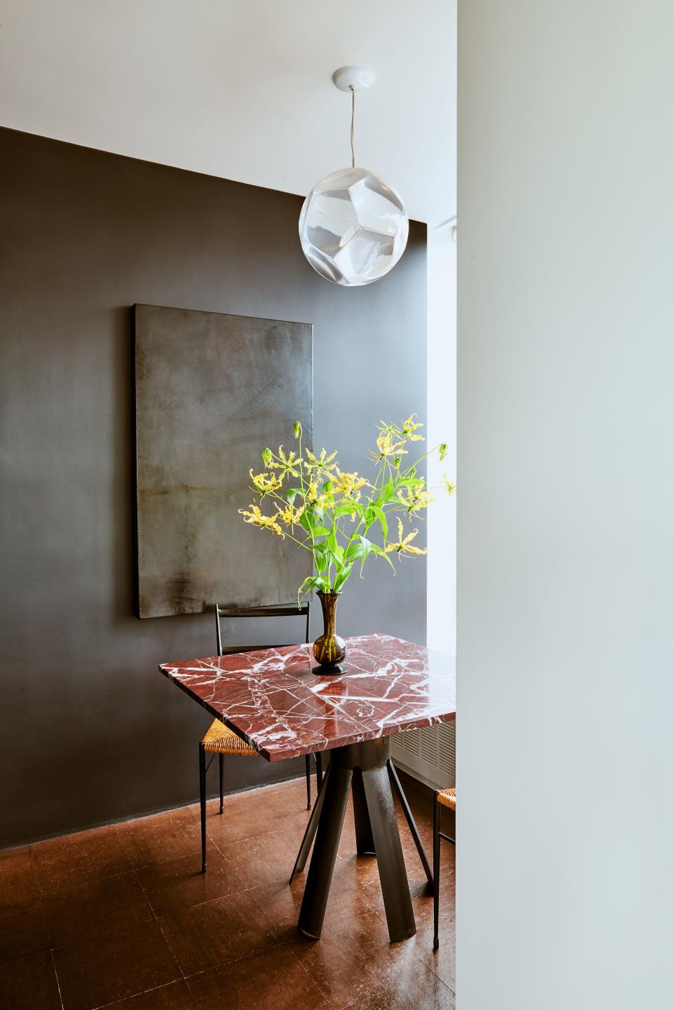 In the breakfast nook, Mann placed an intriguing self-portrait by contemporary artist Benjamin Cottam, which was glazed over in black. “I think the work is about looking more intensely,” says Mann. “I have to tell people to look for the face.” The light pendant above the marble-topped table (with an Angelo Mangiarotti base) has an optical trick as well: Look through the pentagram-shaped acrylic lenses, and everything appears magnified.