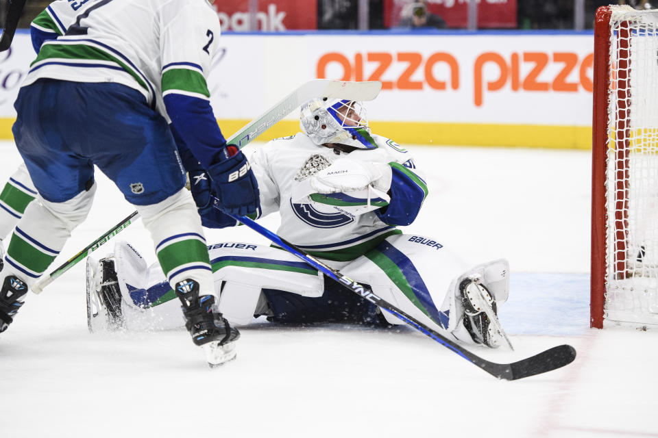 Vancouver Canucks goaltender Spencer Martin (30) watches the puck enter the net by Toronto Maple Leafs defenseman Jordie Benn (18) during the second period of an NHL hockey game in Toronto, Saturday, Nov. 12, 2022. (Christopher Katsarov/The Canadian Press via AP)