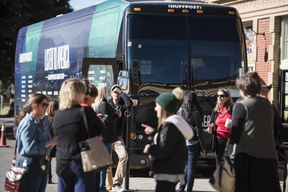 Pedestrians visit the HuffPost bus.