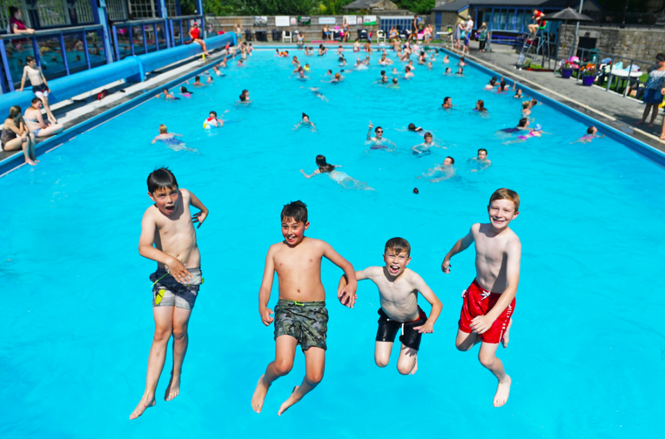 People play in the water at Hathersage Outdoor Swimming Pool in Derbyshire on the hottest July day ever