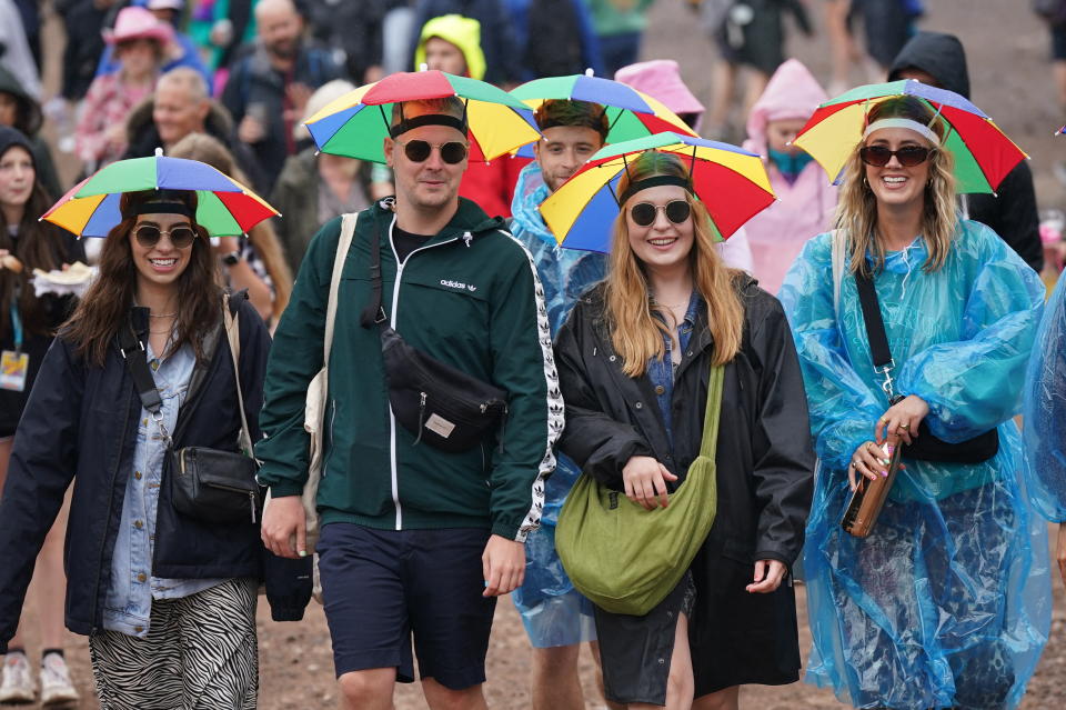 Festival goers in the rain during the Glastonbury Festival at Worthy Farm in Somerset.