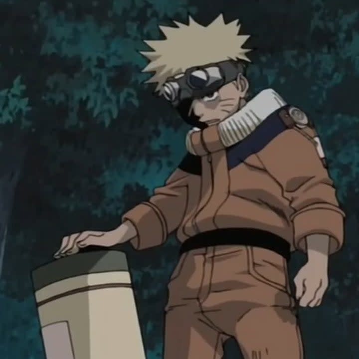 Naruto holding a scroll ready to fight as he is defending his sensei