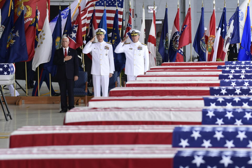 Vice President Mike Pence, left, Commander of U.S. Indo-Pacific Command Adm. Phil Davidson, center, and Rear Adm. Jon Kreitz, deputy director of the POW/MIA Accounting Agency, attend at a ceremony marking the arrival of the remains believed to be of American service members who fell in the Korean War at Joint Base Pearl Harbor-Hickam, Hawaii, Wednesday, Aug. 1, 2018. North Korea handed over the remains last week. (AP Photo/Susan Walsh)