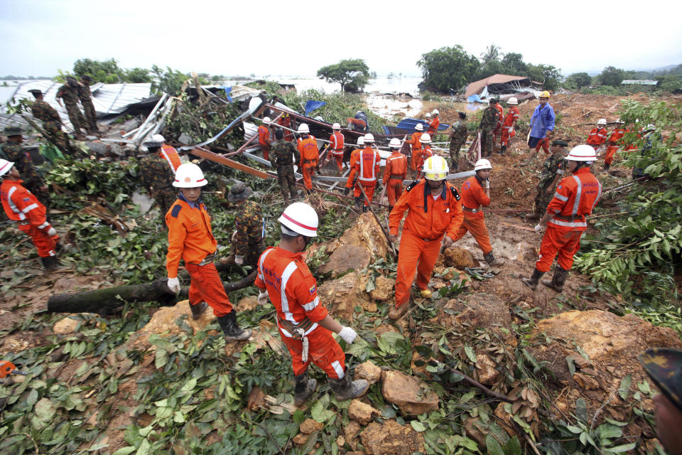 Members of a Myanmar rescue team gather at a landslide-hit area in Paung township, Mon State, Myanmar Saturday, Aug. 10, 2019. A landslide has buried more than a dozen village houses in southeastern Myanmar. (AP Photo)