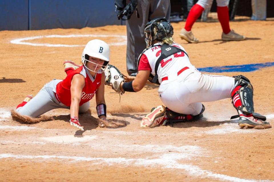 Butler’s Lillie Walker, left, slipped past Daviess County catcher Miller Roberts to score a run during the KHSAA State Softball Championship at John Cropp Stadium.