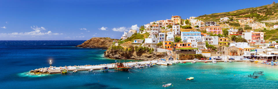 Crete, Greece. Harbour with marine vessels, boats and lighthouse. View from cliff on Bay with beach and architecture Bali - vacation destination resort with clear ocean water, Rethymno