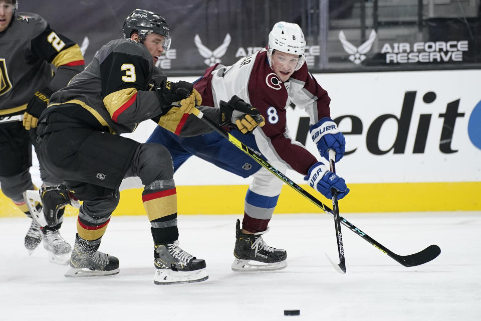 Colorado Avalanche defenseman Cale Makar (8) passes around Vegas Golden Knights' Brayden McNabb during the third period of an NHL hockey game Monday, May 10, 2021, in Las Vegas. (AP Photo/John Locher)