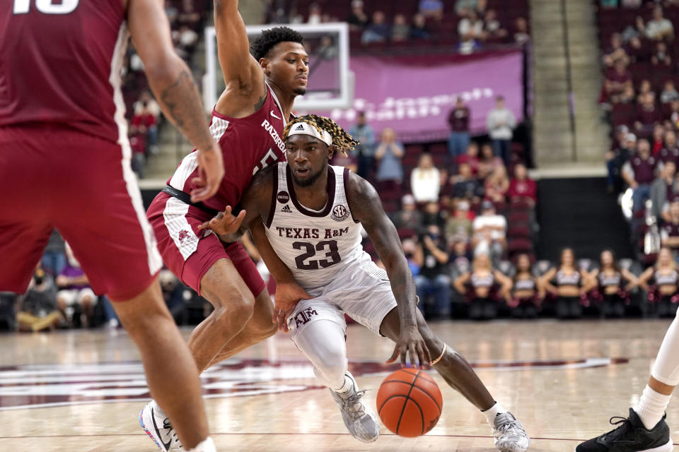 Texas A&M guard Tyrece Radford (23) drives the lane against Arkansas guard Au'Diese Toney (5) during the second half of an NCAA college basketball game Saturday, Jan. 8, 2022, in College Station, Texas. (AP Photo/Sam Craft)