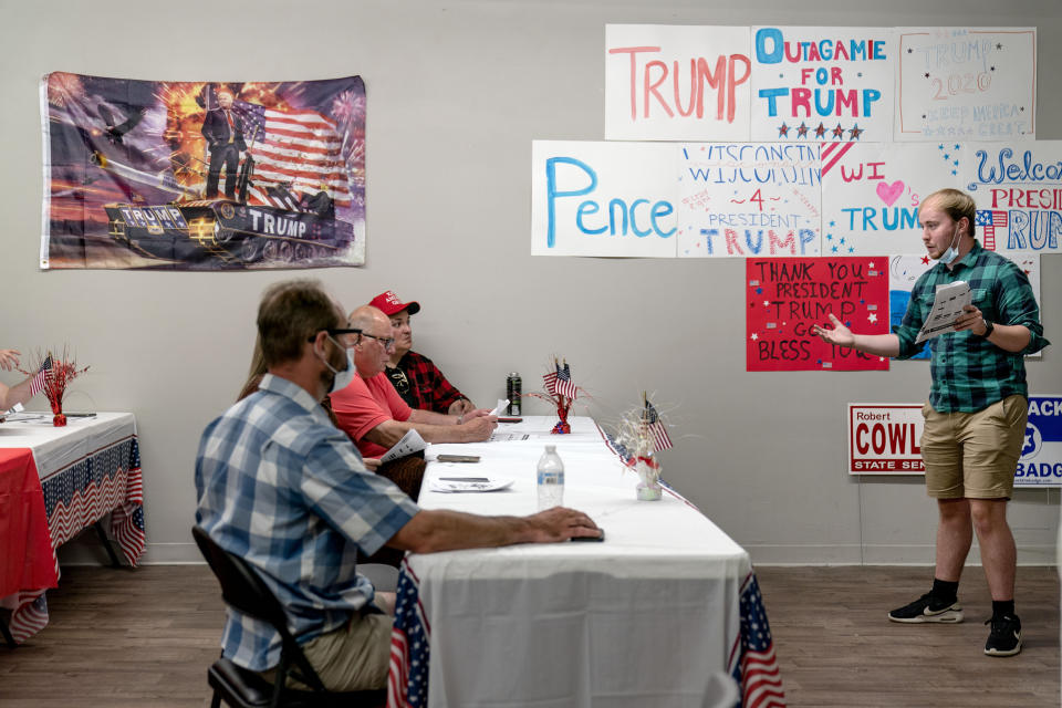 Ryan Retza, right, Trump Victory regional field director, leads volunteers in a training event at a campaign office in Appleton, Wis., Aug. 20, 2020. Republicans here say that President Donald Trump propelled the country to new heights with tax and regulatory cuts, only to be brought low by the force majeure of a virus, and that most voters will hold him blameless. (AP Photo/David Goldman)