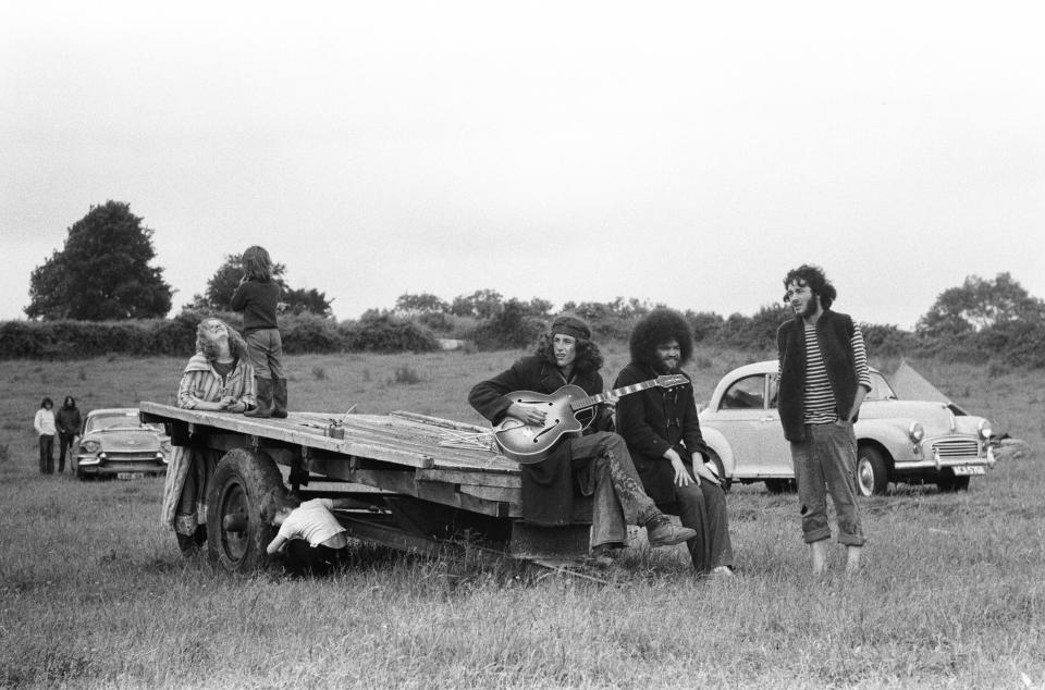 A group of friends attend the then-called 'Glastonbury Fayre' in 1971 chilling out and playing guitar in the open air.