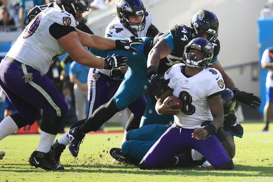 Baltimore Ravens quarterback Lamar Jackson (8) is tackled by Jacksonville Jaguars linebacker Travon Walker (44) during the third quarter of a regular season NFL football matchup Sunday, Nov. 27, 2022 at TIAA Bank Field in Jacksonville. The Jaguars edged the Ravens 28-27. [Corey Perrine/Florida Times-Union]