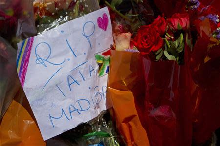 A note paying tribute to Nelson Mandela is placed along with flowers in front of the Town Hall in Cape Town December 6, 2013. REUTERS/Mark Wessels