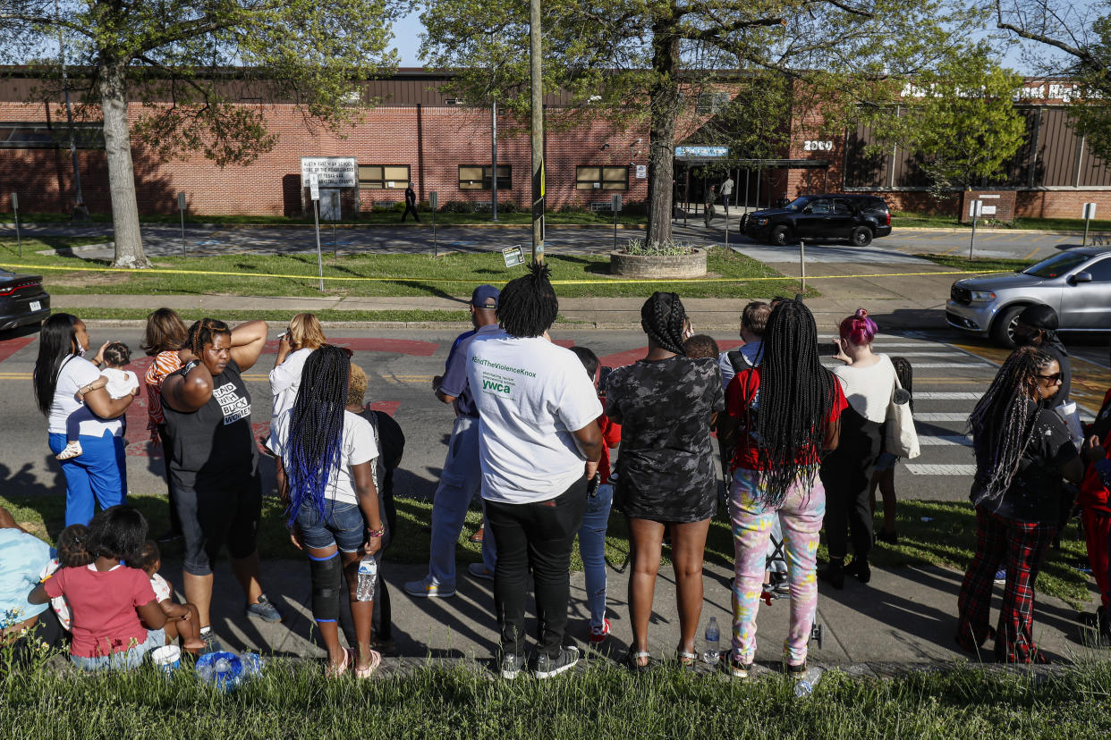 People look on as Knoxville police work the scene of a shooting at Austin-East Magnet High School Monday, April 12, 2021, in Knoxville, Tenn. (AP Photo/Wade Payne)