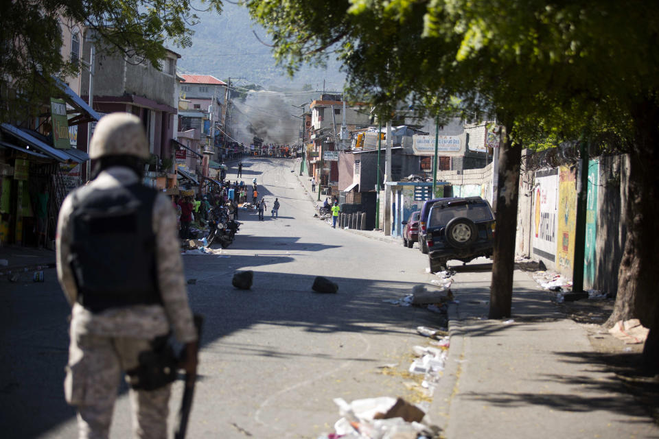 National Police face off with demonstrators during a strike that is part of protests demanding to know how Petro Caribe funds have been used by the current and past administrations, in Port-au-Prince, Haiti, Monday, Nov. 19, 2018. Much of the financial support to help Haiti rebuild after the 2010 earthquake comes from Venezuela's Petro Caribe fund, a 2005 pact that gives suppliers below-market financing for oil and is under the control of the central government. (AP Photo/Dieu Nalio Chery)