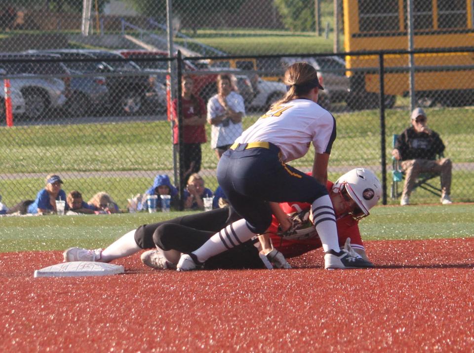 Mooresville sophomore Zoey Kugelman (21) tags out a runner trying to steal second during the first round of the IHSAA Sectional game against Center Grove on Monday.